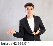 Smiling surprised young male student in suit jacket pointing at you.Portrait of guy pointing finger. Стоковое фото, фотограф Яков Филимонов / Фотобанк Лори