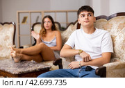 Outraged woman scolding husband while sitting on sofa in room. Стоковое фото, фотограф Яков Филимонов / Фотобанк Лори