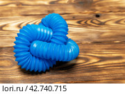 blue children's corrugated pipe toy. Pop Tubes, pipe accordion, antistress. on Wooden Surface. Стоковое фото, фотограф Андрей Знаменский / Фотобанк Лори