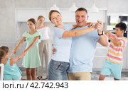 Happy cheerful parents together with children dancing in living room at home. Стоковое фото, фотограф Яков Филимонов / Фотобанк Лори