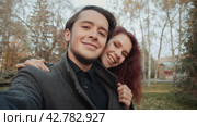 Couple of loving young people is taking photo themselves in the city autumnal park. Стоковое видео, видеограф EStarodubov / Фотобанк Лори