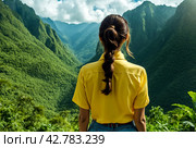 Rear view of lady enjoy at landscape Adam's peak mountain at tropical journey Sri Lanka, Ella, posing. From behind of adult woman in yellow jacket at landmark nature background. Copy ad text space. Стоковое AI-изображение, AI-художник Aleksandr Golubev / Фотобанк Лори