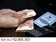 Девушка считает деньги чтобы положить на сберкнижку (2024 год). Редакционное фото, фотограф MК / Фотобанк Лори
