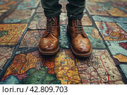 Legs of a man in stylish brown leather lace-up shoes standing on a surface covered with a large map. The map appears to be ancient, with images of lands, bodies of water and names in Latin, done in a traditional style. Стоковое AI-изображение, AI-художник Анна Кривицкая / Фотобанк Лори