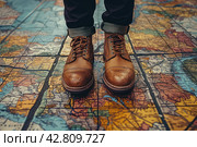 Legs of a man in stylish brown leather lace-up shoes standing on a surface covered with a large map. The map appears to be ancient, with images of lands, bodies of water and names in Latin, done in a traditional style. Стоковое AI-изображение, AI-художник Анна Кривицкая / Фотобанк Лори