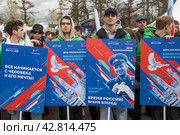 Участники космического шествия держат плакат с портретом Юрия Гагарина в день космонавтики 12 апреля на ВДНХ в городе Москве, Россия (2024 год). Редакционное фото, фотограф Николай Винокуров / Фотобанк Лори