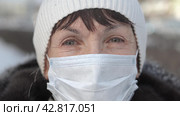 Portrait close up of middle aged woman out and about in the city streets wearing in a protective face mask looking at camera. Quarantine coronavirus covid-19. Стоковое видео, видеограф EStarodubov / Фотобанк Лори