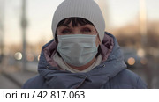 Portrait of retirement age woman wearing face mask look anxious and worried in the city. Disease, covid-19, epidemic medication concept. Стоковое видео, видеограф EStarodubov / Фотобанк Лори
