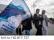 Студентки Московского государственного университета иду с баннером по улице на ВДНХ в городе Москве (2024 год). Редакционное фото, фотограф Николай Винокуров / Фотобанк Лори