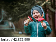 A child and a fly agaric. The boy with the fly agaric. A dangerous poisonous mushroom in the hands of a child. Mushroom poisoning, microdosing, eating herbal medicine. Стоковое фото, фотограф Photojuli / Фотобанк Лори