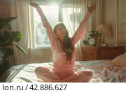 Woman Sitting on Top of Bed With Arms Raised. Стоковое AI-изображение, AI-художник Юлия Гапеенко / Фотобанк Лори