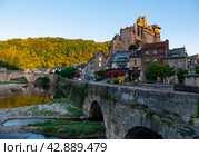 French township of Estaing on bank of Lot River with arched bridge and fortified castle. Стоковое фото, фотограф Яков Филимонов / Фотобанк Лори