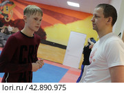 Тренер Дмитрий Яковлев и организатор спортивной школы в Железнодорожном, во время тренировки детей (2024 год). Редакционное фото, фотограф Дмитрий Неумоин / Фотобанк Лори