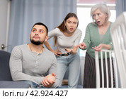 Man dont speaking after discord with mother and wife standing behind. Стоковое фото, фотограф Яков Филимонов / Фотобанк Лори