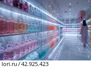 Interior interior of a modern cosmetics store with rows of neatly organized products displayed on illuminated shelves. The interior features clean lines, shiny marble floors with reflections and stylish lighting that creates a subdued atmosphere. The store appears spacious and empty, reinforcing the feeling of exclusivity and high quality of the products on offer. Стоковое AI-изображение, AI-художник Анна Кривицкая / Фотобанк Лори