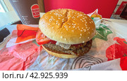 Moscow April 10 2024, Big burger with two patties on a tray in burger king. Burger on a tray in fast food restaurant close-up. Fast food restaurant and self-service checkouts. Редакционное фото, фотограф Скрипачев Антон / Фотобанк Лори