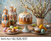 Orthodox Easter. Easter cake, painted eggs, icons, faces of saints, flowers, church candles and Easter decor on a wooden table in an old village house. Стоковое AI-изображение, AI-художник Photojuli / Фотобанк Лори