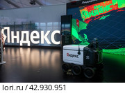 Робот-курьер "Яндекса" на фоне изображения камеры робота представлен на Международной выставка-форуме "Россия" на территории выставочного комплекса ВДНХ в городе Москве, Россия (2024 год). Редакционное фото, фотограф Николай Винокуров / Фотобанк Лори