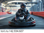 male racer in a helmet driving a go-kart on an indoor track looking at the camera. Стоковое AI-изображение, AI-художник Александр Довянский / Фотобанк Лори
