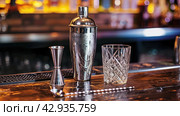 barware on the bar counter close-up, shaker, jigger, glass. Стоковое AI-изображение, AI-художник Александр Довянский / Фотобанк Лори