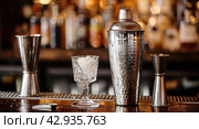 barware on the bar counter close-up, shaker, jigger, glass. Стоковое AI-изображение, AI-художник Александр Довянский / Фотобанк Лори