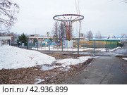 Petrozavodsk, Karelia, Russia, April 19, 2024: Park of culture and recreation, amusement park. Carousels, rides, swings and spinners in the spring under snow. Entertainment for children and adults. Редакционное фото, фотограф Юлия Петровская / Фотобанк Лори