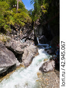 ARSHAN VILLAGE, TUNKINSKIY DISTRICT, BURYATIA, RUSSIA -  August 12, 2023: Tourists came along Health Path to beautiful waterfall on mountain river Kyngarga in Tunkinsky Park reserve on summer day. Редакционное фото, фотограф Виктория Катьянова / Фотобанк Лори
