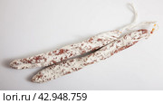Close-up of spiced spanish fuet sausages at white background. Стоковое фото, фотограф Яков Филимонов / Фотобанк Лори