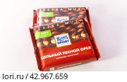 Moscow April 02, 2024. Ritter Sport milk chocolate from well-known manufacturer. Milk chocolate with whole hazelnuts close-up on white background. Редакционное фото, фотограф Скрипачев Антон / Фотобанк Лори