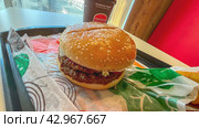 Moscow April 10 2024, Big burger with two patties on a tray in burger king. Burger on a tray in fast food restaurant close-up. Fast food restaurant and self-service checkouts. Редакционное фото, фотограф Скрипачев Антон / Фотобанк Лори