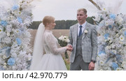 The bride and groom at an outdoor marriage registration holding hands. Стоковое видео, видеограф Mikhail Davidovich / Фотобанк Лори