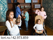 Friends solving different conundrum as detectives in quest room with old furnitures. Стоковое фото, фотограф Яков Филимонов / Фотобанк Лори