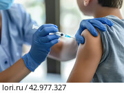 Child receiving a vaccination. Little boy in face mask in doctor's office is vaccinated. Kid giving injection shot. Syringe with covid-19, coronavirus, flu vaccine. Dangerous infectious disease, MPOX. Стоковое AI-изображение, AI-художник Марина Демидюк / Фотобанк Лори