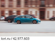 Blue car Toyota Prius Prime drives fast on the city road. Редакционное фото, фотограф Константин Григорьев / Фотобанк Лори