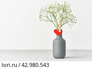 Valentine's Day. Delicate white flowers in a vase. Red felt heart - symbol of lovers. Стоковое фото, фотограф Natalia Gdovskaia / Фотобанк Лори