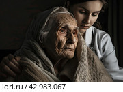 A young granddaughter takes care of an elderly grandmother. Taking care of the older generation. Стоковое AI-изображение, AI-художник Ярославский Максим / Фотобанк Лори