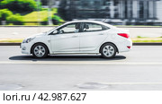 White sedan Hyundai Solaris Accent fast speed driving on the asphalt road. Редакционное фото, фотограф Константин Григорьев / Фотобанк Лори
