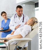 Male beautician, together with a nurse, examines the face of an mature woman and plans facelift procedures. Стоковое фото, фотограф Яков Филимонов / Фотобанк Лори