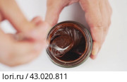 Stirring of chocolate paste with a spoon on white table. Стоковое видео, видеограф Гурьянов Андрей / Фотобанк Лори