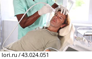 European man undergoes facial skin moisturizing procedure with hydrogen-oxygen hydrating nozzle. Стоковое видео, видеограф Яков Филимонов / Фотобанк Лори