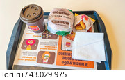 Moscow April 10 2024, Ordering on a tray at a burger king. Fast food restaurant and self-service checkouts. Burger KING fast food restaurant with double whopper. Редакционное фото, фотограф Скрипачев Антон / Фотобанк Лори