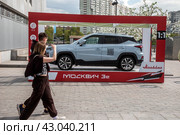 Вид на новый электромобиль "Москвич 3е", который стоит на площади у здания Южного речного вокзала в городе Москве, Россия (2024 год). Редакционное фото, фотограф Николай Винокуров / Фотобанк Лори