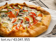 Close up homemade savory galette with vegetables, wheat pie with tomatoes, zucchini, Стоковое фото, фотограф Natalia Gdovskaia / Фотобанк Лори