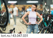 Avid female cyclist exploring variety of bicycles in store. Стоковое фото, фотограф Яков Филимонов / Фотобанк Лори