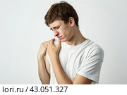 Young man with pain in shoulder, upper arm. Human body health problem banner. Male boy is enduring awful ache. Upset person with muscle nerve pain symptoms holding a hand on painful zone injured point. Стоковое AI-изображение, AI-художник Марина Демидюк / Фотобанк Лори