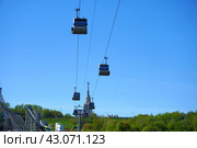 Cabins of the Moscow cable car on the background of the Vorobyovy Gory and the spire of Moscow State University. Russia. Moscow. 29.04.2024. Редакционное фото, фотограф Ярославский Максим / Фотобанк Лори
