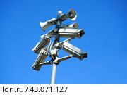 A pole on the street with cameras and loudspeakers mounted on it against a blue sky background (2024 год). Редакционное фото, фотограф Ярославский Максим / Фотобанк Лори