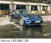 Автомобиль Porsche Taycan синего цвета стоит на парковке (2024 год). Редакционное фото, фотограф Константин Григорьев / Фотобанк Лори