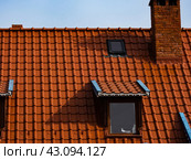 Roof of a house made of red tiles with a chimney and attic. Стоковое фото, фотограф Наталья Симакова / Фотобанк Лори