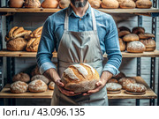 Fresh delicious bread in the hands of a male baker in close-up. Freshly baked sourdough bread with a golden crust on a wooden board. The context of a bakery with delicious bread. Confectionery products. Стоковое AI-изображение, AI-художник Photojuli / Фотобанк Лори
